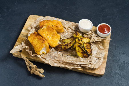 英语传统鱼和木切削板上的薯片暗底图片