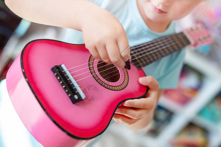 尤腾青年在家学弹小四轮吉他玩得开心背景