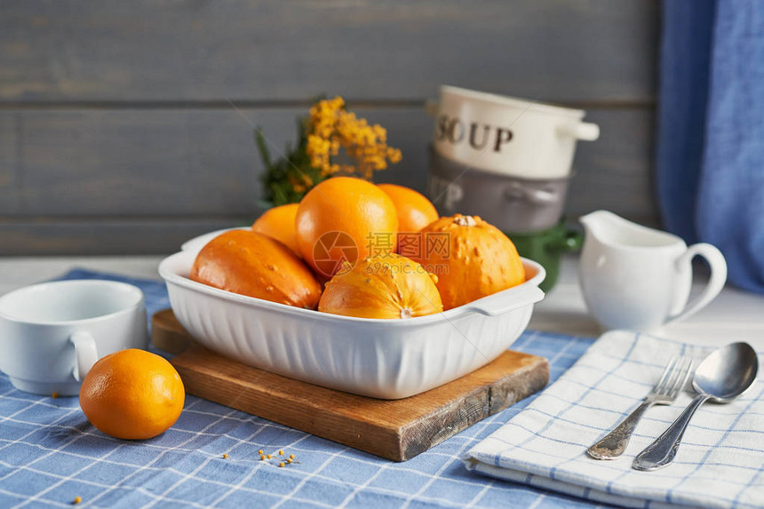 烹饪前桌上的橙子和南瓜图片