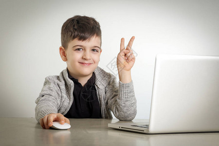 有笑脸的男孩在笔记本电脑前图片