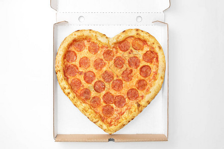 比萨心形顶视图在纸板箱交付情人节隔离在白色背景从上面查看情人节概念比萨饼交付背景图片