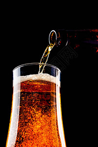 啤酒倒在玻璃杯里从瓶子图片