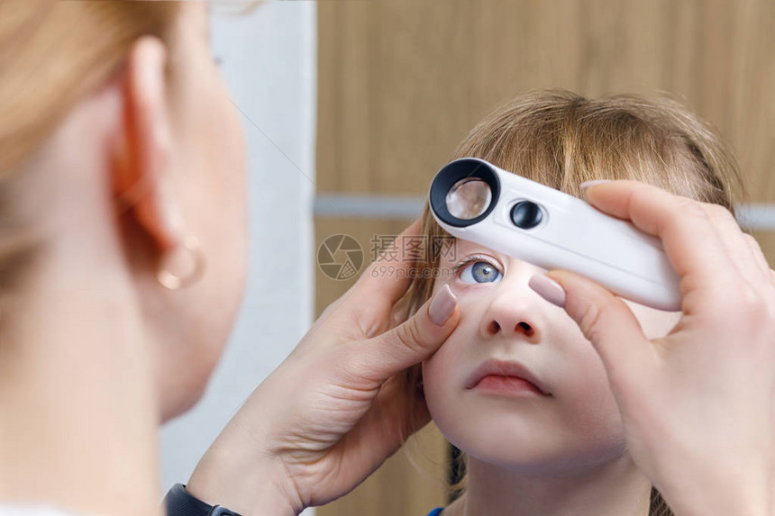 女眼科医生在病房背景下用特殊设备检查小孩眼睛或进行治疗后检查的特写镜头眼部问图片