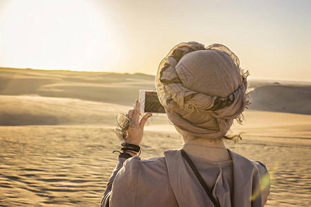 在埃及西瓦Siwa沙漠拍摄日落的年轻女身戴图片