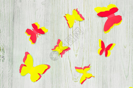 木制背景的多彩纸蝴蝶儿童发展活动申请和折纸图片