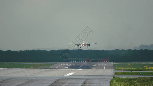 双引擎商用飞机接近降落机场的中距离拍摄图片