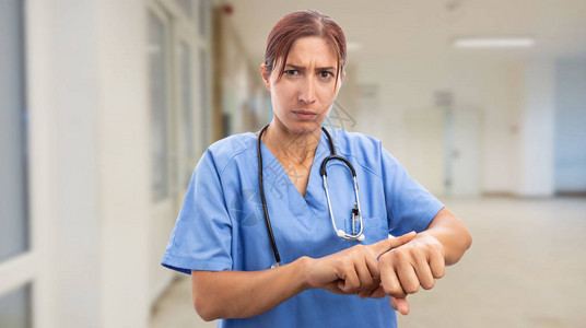 愤怒的护士妇女用食指对手腕指着很晚图片