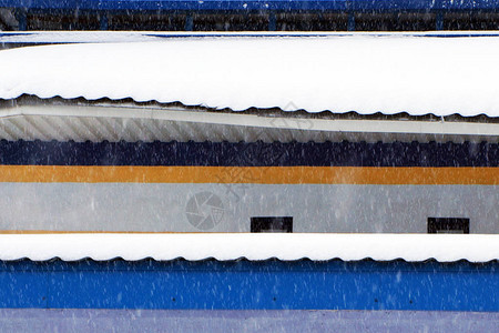 冬天在街道上降雪积雪覆盖建筑物的屋顶图片