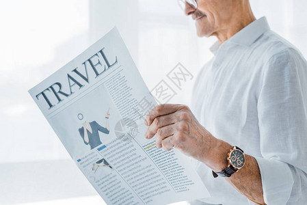 老人在家阅读旅游报纸的作物风图片