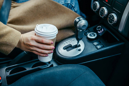 女人用手拿咖啡在车里喝图片