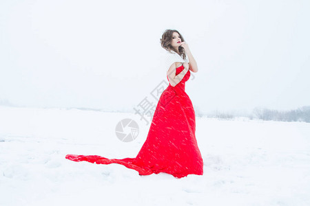 在雪田上穿红裙子的女孩图片