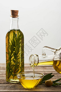 将橄榄油从瓶中倒入玻璃碗中图片