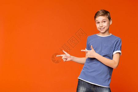 可爱的小男孩向外指着橙色工作室背图片