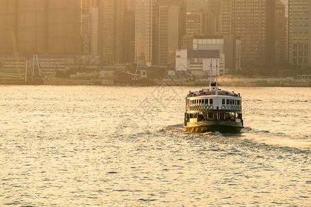 清晨黎明时有城市风景背的Victoria港绿色旅客渡轮图片