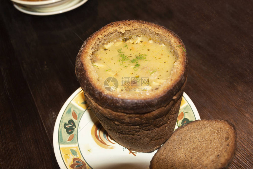 面包碗里的新鲜豌豆汤放在木板上图片