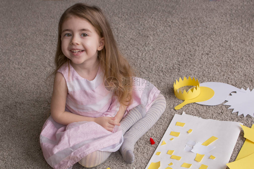 可爱的4岁小女孩用彩纸装饰打孔器和彩纸制作精美的应用装饰品图片