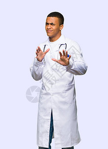 年轻的美国年轻男医生有点紧张害怕在孤立的背景下把双手伸到前门图片