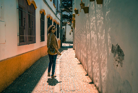 旅游女孩走在一条狭窄的老街上图片