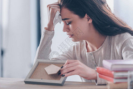 有选择焦点心烦意乱的女人拿着照片图片