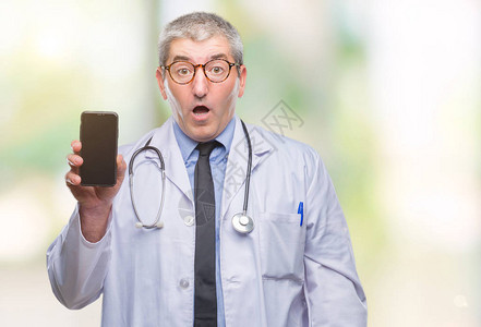 英俊的高级医生在与世隔绝的背景下展示smarpthone屏幕图片