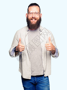 年轻的金发男子戴着眼镜成功标志用手做积极的手势图片