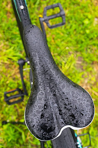 在山地自行车雨后紧贴一个湿脚踏车座椅图片