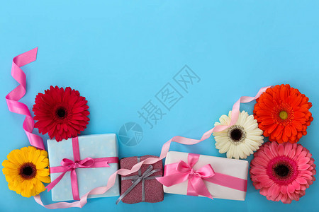 彩色背景上鲜花美丽的礼物盒图片