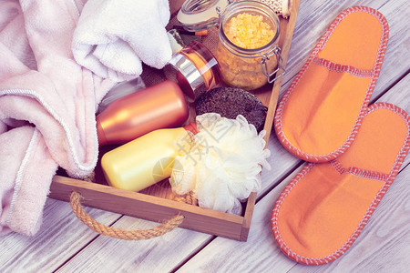 SPA由橙色拖鞋浴袍毛巾和其他用木盘洗图片