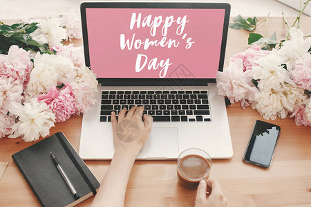 笔记本电脑屏幕上的妇女节快乐文字标志背景图片