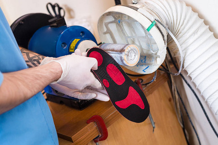 为患有腿部疾病扁平足的人制造矫形个人鞋垫的过程一名员工的手特写镜头敦促车间机床图片