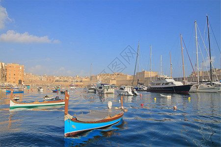 这张照片是在一月份在马耳他岛上拍摄的在照片早晨在Senglea镇附近的海港停泊的小船和游背景