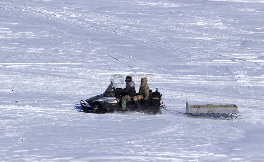 渔民雪地摩托骑在结冰的河面上图片