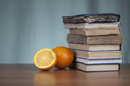木桌上的书堆和橙片图片