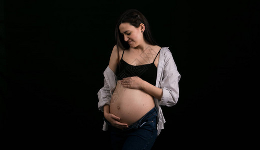 黑色背景的孕妇肖像怀孕的概念和图片
