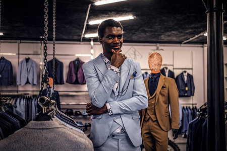 一位穿着时尚优雅的非洲裔美国人站在一家经典男装店里图片