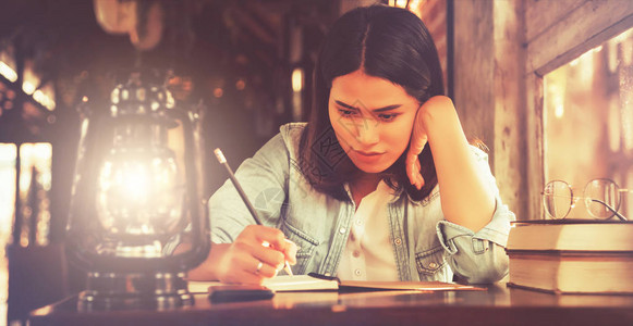 年轻的年轻女学生在咖啡店咖啡厅写笔记图片