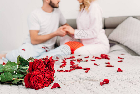 部分看到一对夫妇用玫瑰花瓣坐在图片
