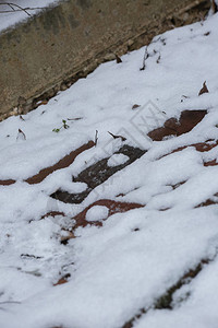 从薄的雪层中探出的红砖图片