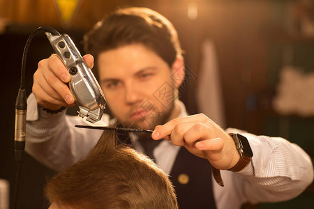 有选择地专注于专业理发师手中的理发剪图片