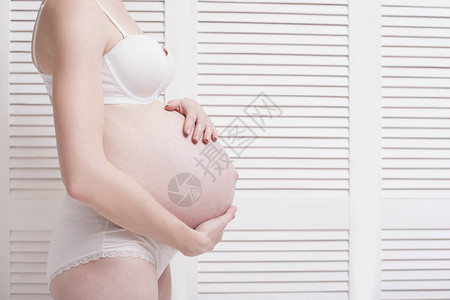 身穿内裤的孕妇抱着肚子图片