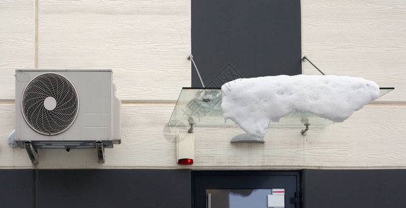 住宅楼门窗外玻璃树冠上的空调和雪图片