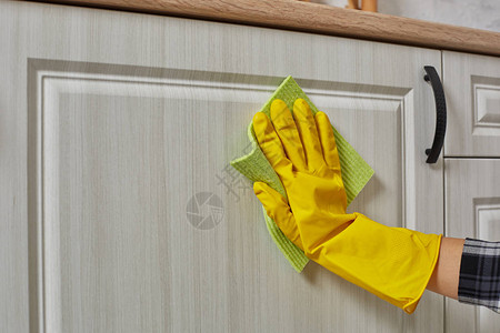 戴着绿色抹布手套的手正在清洁厨柜家务和家图片