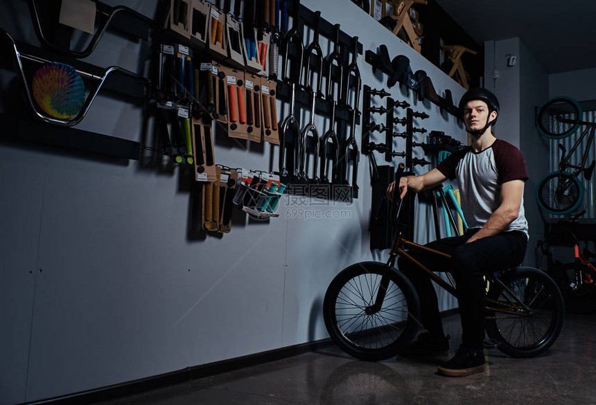 专业的BMX骑手坐在自行车店的图片