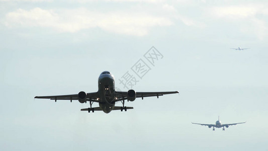 商业飞机在早上起飞机接近降落在背景位置的着陆图片