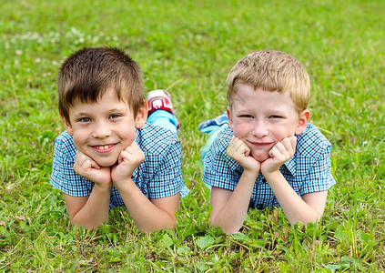 七岁的双胞胎躺在草坪上夏天躺在图片