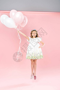 无忧虑的孩子在双色背景上用白色和粉红色的气球跳跃图片