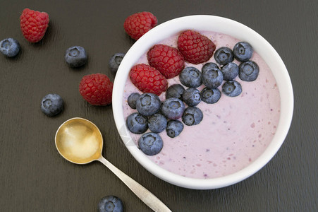 蓝莓酸奶在木制桌背景图片