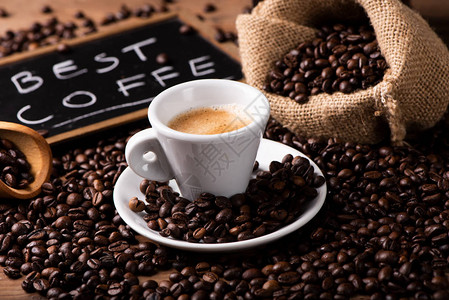 Expresso咖啡杯特写在深烤咖啡豆上图片