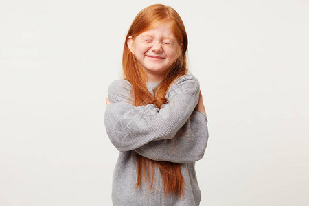 长着红头发的小女孩闭着眼睛看起来很开心图片