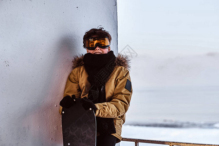 一名十几岁的滑雪车手身着温暖衣服和护目镜图片